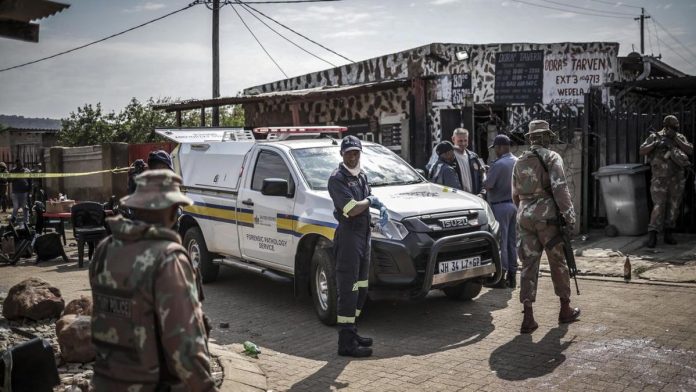Members of South Africa's Forensic Pathology Service and South African National Defence Force (SANDF) inspect and secure the scene where gunmen armed with assault rifles stormed a bar in Johannesburg on September 27, 2026. Gunmen killed at least 27 p